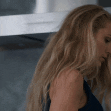 a close up of a woman 's face with long blonde hair