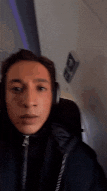 a young man wearing headphones is sitting on an airplane