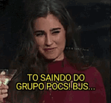 a woman is holding a martini glass and smiling .