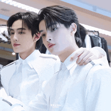 two men in white shirts are standing next to each other with 24145 written on the bottom