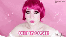 a woman with pink hair and blue eyes is making a funny face and says oh my gosh .