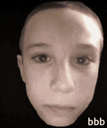 a close up of a child 's face with a black background and the word bbb on it .