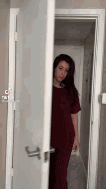 a woman is standing in a doorway looking out of it .