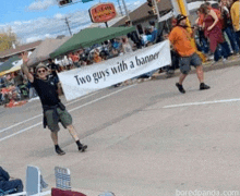 a man is holding a sign that says two guys with a banner