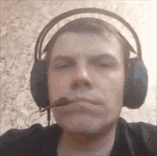 a man wearing headphones and a microphone makes a funny face