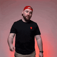 a man wearing a red hat and a black shirt with a red shield on the front