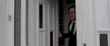 a man in a suit and tie stands in a doorway