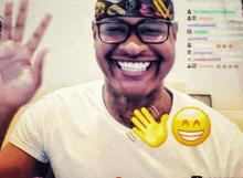 a man wearing glasses and a hat is smiling with a yellow smiley face in front of him