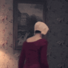 a woman in a red dress is standing on a man 's lap
