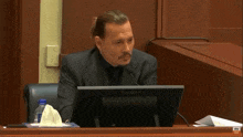 a man sits at a desk with a flatron monitor