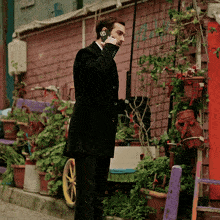 a man in a black suit talking on a cell phone with a sticker on his phone that says ' a ' on it