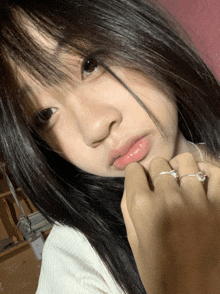 a close up of a woman 's face with her hand on her face