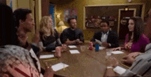 a group of people are sitting around a table in a room .