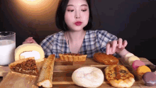 a woman is sitting at a table eating bread