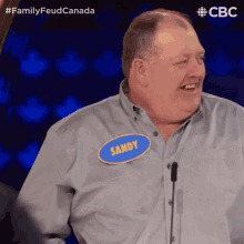 a man with a name tag on his shirt that says sandy