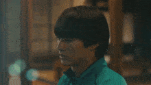 a close up of a person 's face with a green jacket on