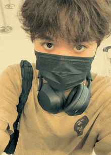 a man wearing a mask and headphones has a shirt with the letter a on it
