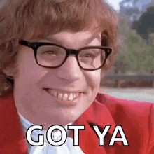 a man wearing glasses and a red jacket is smiling and saying got ya