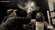 a bearded wrestler is being sprayed with water by another wrestler .