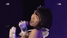 a woman is singing into a microphone with the words live on the bottom