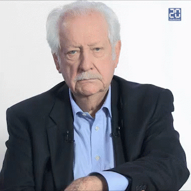 an older man with a mustache is wearing a suit and a blue shirt