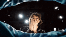 a woman with a ring on her finger covering her face