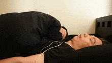 a man is laying in bed with headphones on