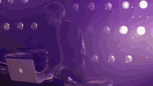 a man with a tattoo on his arm is playing a guitar in a dark room
