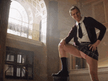 a man in a plaid skirt is kneeling on a bucket