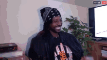 a man wearing a bandana and a t-shirt that says snoop dogg is smiling