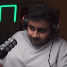 a man is wearing headphones and a rode microphone