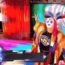 a wrestler wearing a mask and a shirt that says connor 's club is standing on a stage .