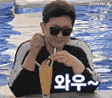 a man wearing sunglasses is drinking a drink through a straw in a swimming pool .