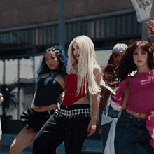 a woman in a red top and black pants is surrounded by other girls