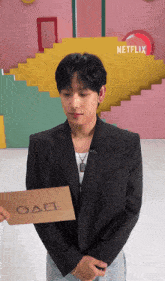 a man in a suit holds a card that says oad on it