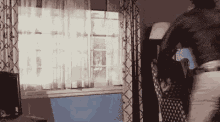 a person is standing in front of a window in a room .
