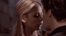 a man and a woman are kissing and the woman has earrings in her ears