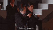 a man in a suit says " rules are absolute " while dancing