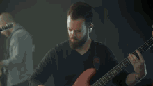 a man singing into a microphone with a guitar in the background