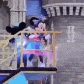 mickey mouse and minnie mouse are dancing on a balcony