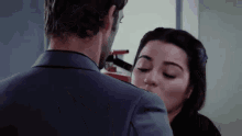a man in a suit kisses a woman on the forehead