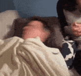a blurry picture of a person laying in bed with a blanket