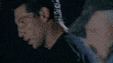 a man in a black shirt is looking at another man
