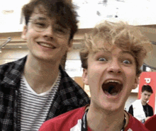 two young men are standing next to each other and one of them is making a funny face .
