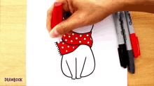 a person is drawing a dog wearing a red scarf with sharpie markers