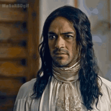a man with long hair and a beard is wearing a white shirt