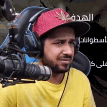 a man wearing headphones and a red hat with a leaf on it
