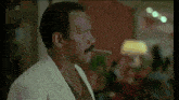 a man with a mustache is smoking a cigar in a restaurant