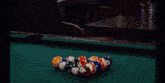 a man playing pool in a bar with a neon sign that says the floating rib
