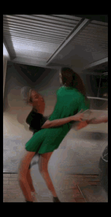 a blurry picture of a woman in a green dress